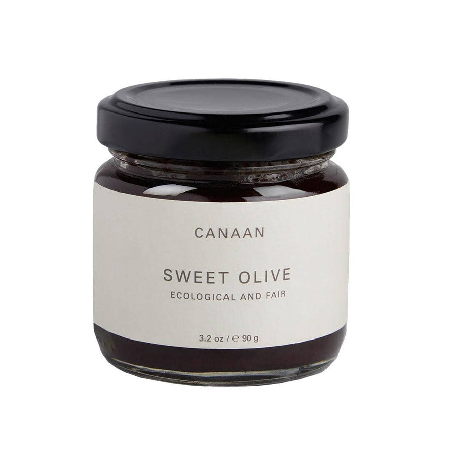 A jar of Canaan Palestine Sweet Olive Spread with a white label on a dark background.