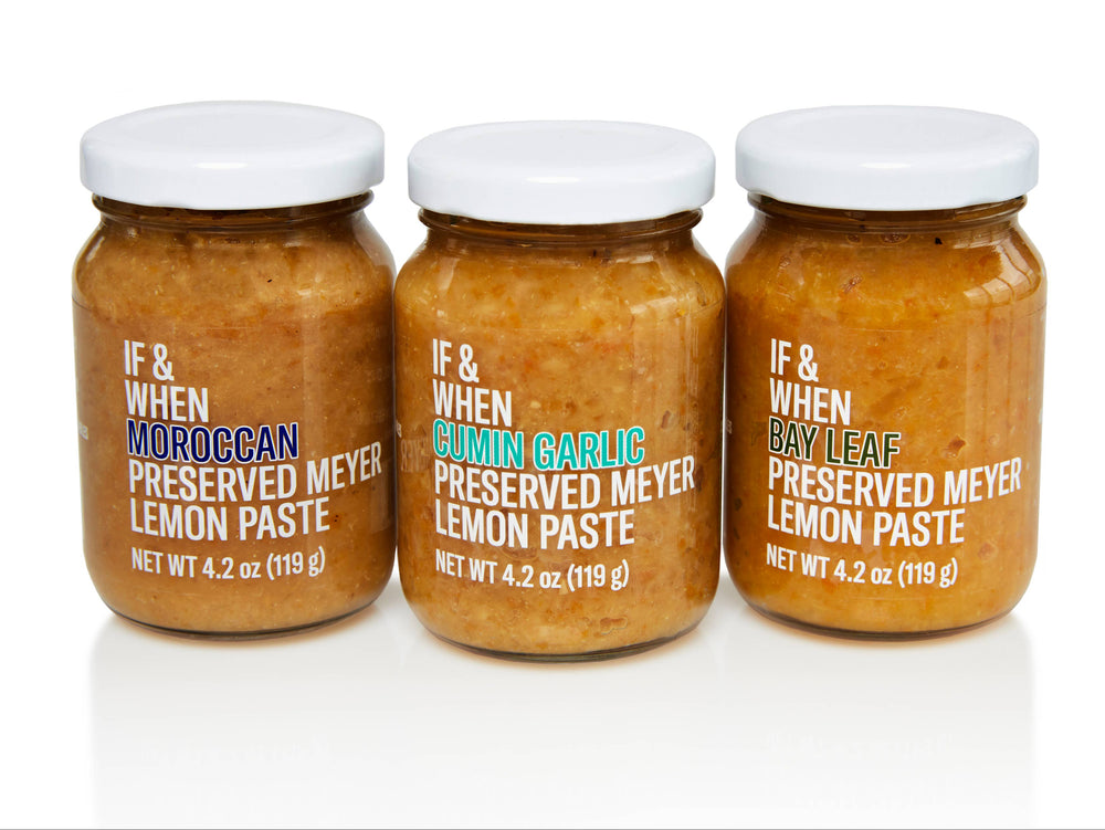 Three jars of preserved Meyer lemon paste, each labeled with a different flavor: Bay Leaf, Cumin Garlic, and Moroccan. The jars are sealed and presented against a white background.